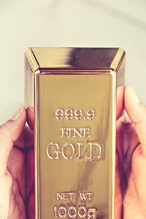 Hand hold gold barsの写真素材