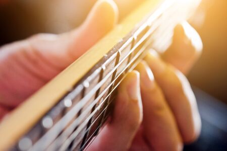 Hands of man playing electric guitar close up
