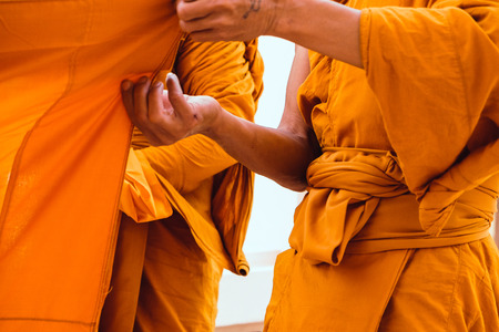 Yellow robe of Buddhist monks, Closeup on buddhist monkの写真素材