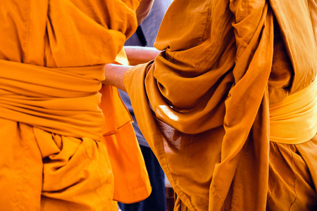 Yellow robe of Buddhist monks, Closeup on buddhist monkの写真素材