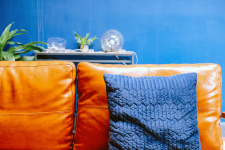 Close up detail of blue pillow on leather sofaの写真素材