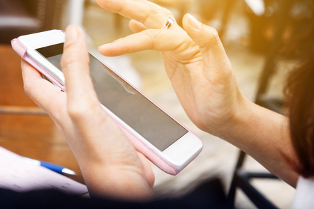 Close up of Young woman using smart phone in cafeの写真素材
