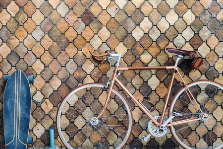 Vintage skateboard and old bicycle parked on old mosaic wall vintageの写真素材