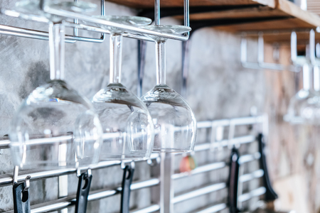 Glasses of wine hanging above a bar rackの写真素材