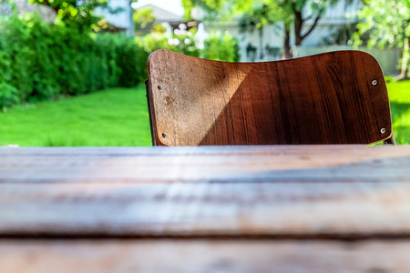 Empty table top and wooden chair with  green garden backgroundの写真素材