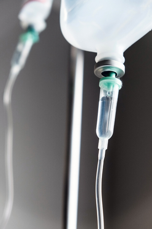 Close up of IV saline solution drip for patient in hospitalの写真素材