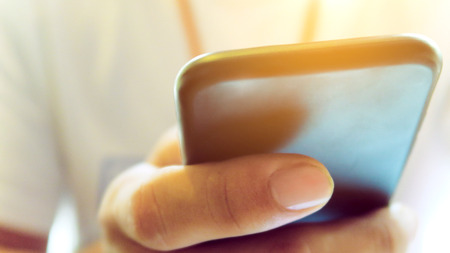 Closeup Image of man's hand holding a smartphone