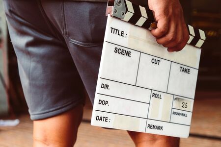 Man hands holding movie clapper.