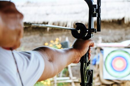 Archer holds his bow aiming at a targetの写真素材