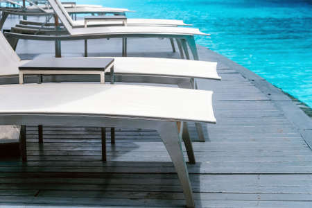 Many white chaise lounge by the pool