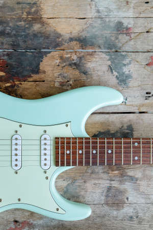 Detail of Mint Green Electric Guitar on a wood background.の写真素材