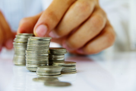 Hands of business man putting coin to money, business and finance conceptの写真素材
