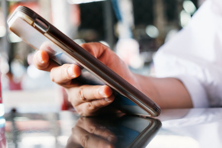 Closeup image of a woman using mobile smart phone at coffee shopの写真素材