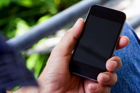 Close up of man hand using smart phone with blank screen for mockupの写真素材