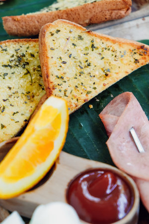 Crispy bread with cheese, ham and herbs on wooden board
