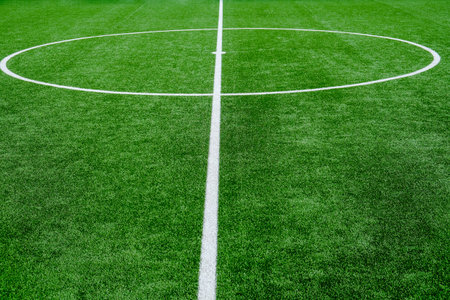 Soccer field with green grass and white line, sport background.