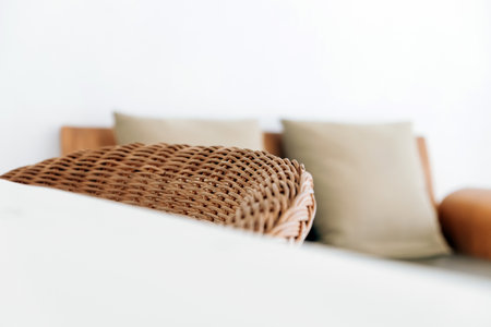 Close up of wicker chair and pillow on sofa in living roomの写真素材