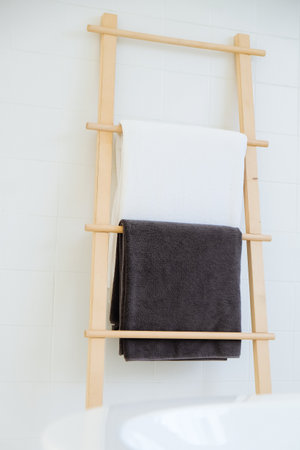 Towel hanging on a wooden ladder in a modern bathroom.の写真素材