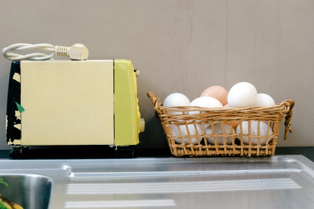 Eggs in a basket and toaster on the kitchen tableの写真素材
