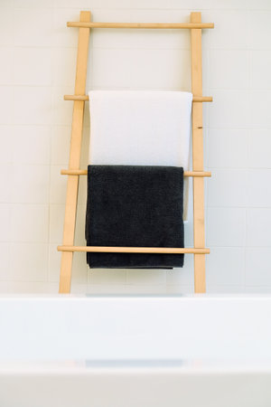 Towel hanging on a wooden ladder in a modern bathroom.の写真素材