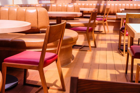 Wooden chairs and tables in a row in the interior of a restaurant