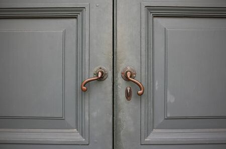 Door handles with an old double wood door の写真素材