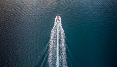 Aerial view of a motorboat proceeding at high speed, plowing through the sea and leaving a wake behindの写真素材