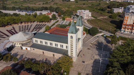 Aerial view of the sanctuary of Our Lady Queen of Peace - Medjugorje. Drone view of the church symbol of the tourist city that attracts tourists and pilgrims in prayer in Bosnia anの写真素材