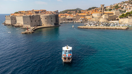 Tourist boats sailing near Dubrovnik old port. Aerial view of small boat in Adriatic sea near city of Croatiaの写真素材