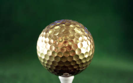Golfball in gold for luxury playの写真素材