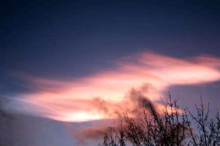 Extreme light phenomenon when the sky lights up after sunset with low clouds coming by.の写真素材