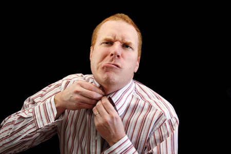 Man trying to button his shirt with some difficulties