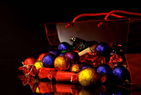 Sweets in a christmas bag with reflection and black backgroundの写真素材