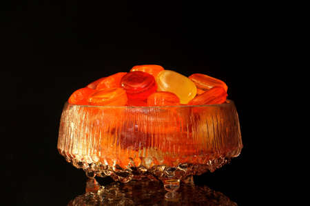 Sweets in a glass bowl with reflection and black backgroundの写真素材