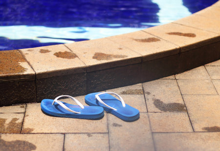 Blue flip-flop shoes by the nice poolsideの写真素材