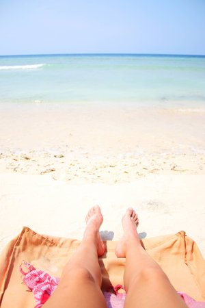 Summer legs on the sandy beach on vacationの写真素材