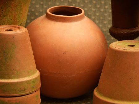 round terra cotta pot among other flower pots