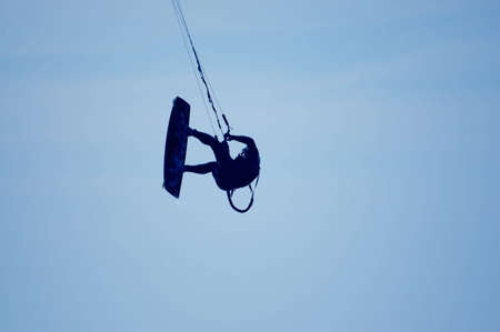 kitesurfing, silhouette of sportmen on blue