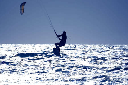 kitesurfing, silhouette of sportmen on blueの写真素材