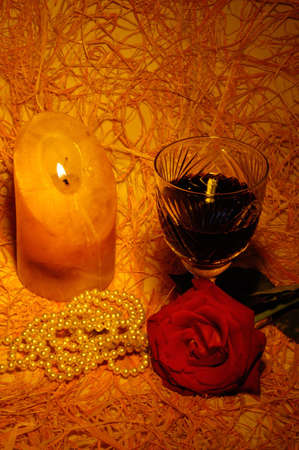 pearls, rose, wine on a straw backgroundの写真素材