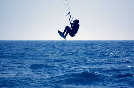 kite surfing, silhouette of sportsmen on blueの写真素材