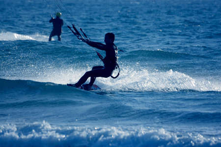 kite surfing, silhouette of sportsmen on blue