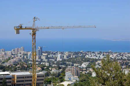 building, cranes on background of Haifa city 