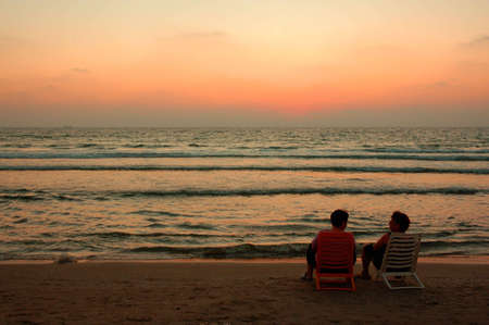 two silhouette on a beach on background of sunsetの写真素材