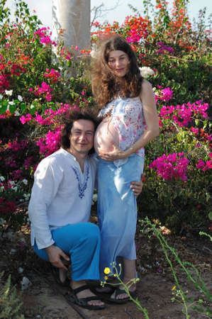 Young happy pregnant woman and  her husband in the country clothesの写真素材