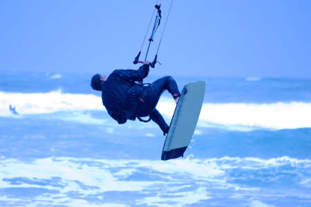 Jumping kite surfer on blue backgroundの写真素材