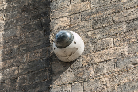 CCTV Camera hanging on Brick Wallの写真素材