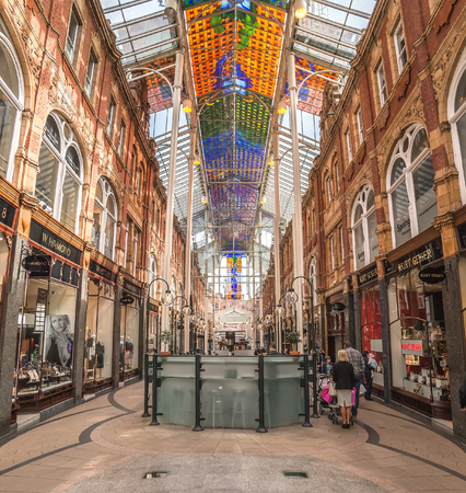 Leeds, UK - April 8, 2015: Victoria Quarter\'s Stained Glass Ceiling and Retail Shops with Shoppers. The Quarter which was restored during which a coloured glass roof was erected over Queen Victoria Street.のeditorial素材