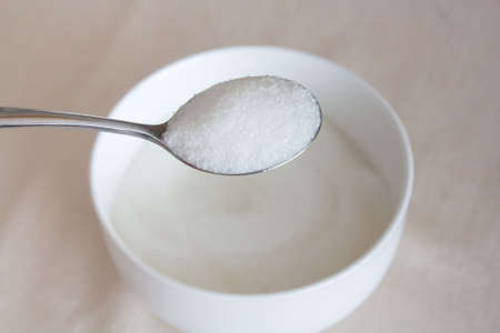 bowl of sugar with stainless spoonの写真素材