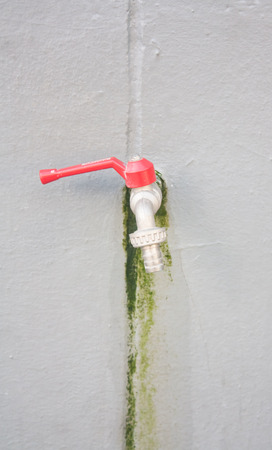 faucet with red cap on white backgroundの写真素材